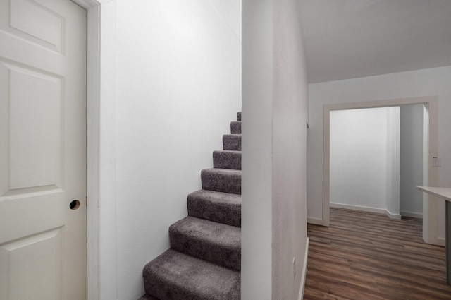 stairs with wood finished floors and baseboards