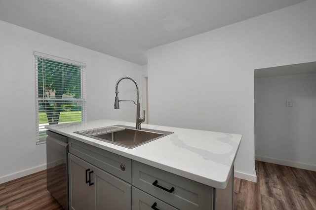 kitchen with a kitchen island with sink, gray cabinetry, a sink, light countertops, and dishwasher