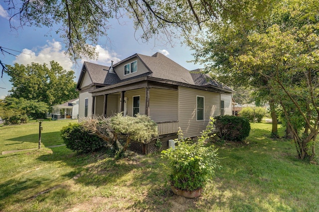 view of property exterior with a porch, a lawn, and roof with shingles