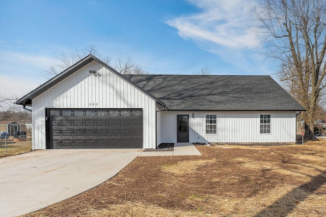 modern inspired farmhouse with a garage, concrete driveway, and roof with shingles