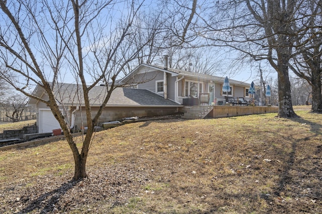 view of side of property featuring a deck, roof with shingles, and an attached garage