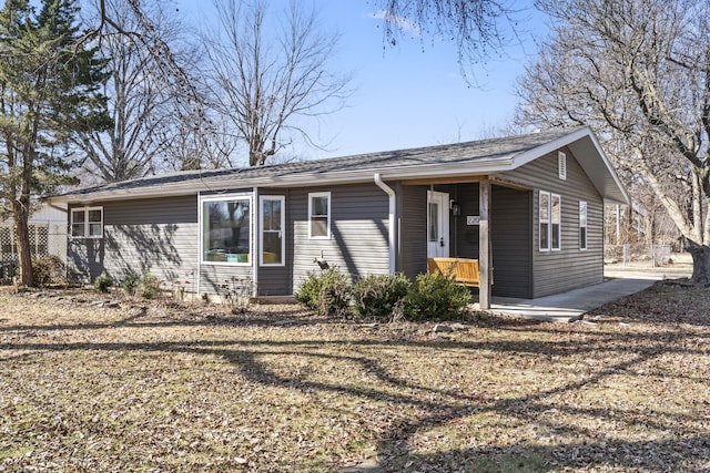 ranch-style home featuring covered porch and fence