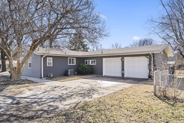 single story home with cooling unit, driveway, and an attached garage