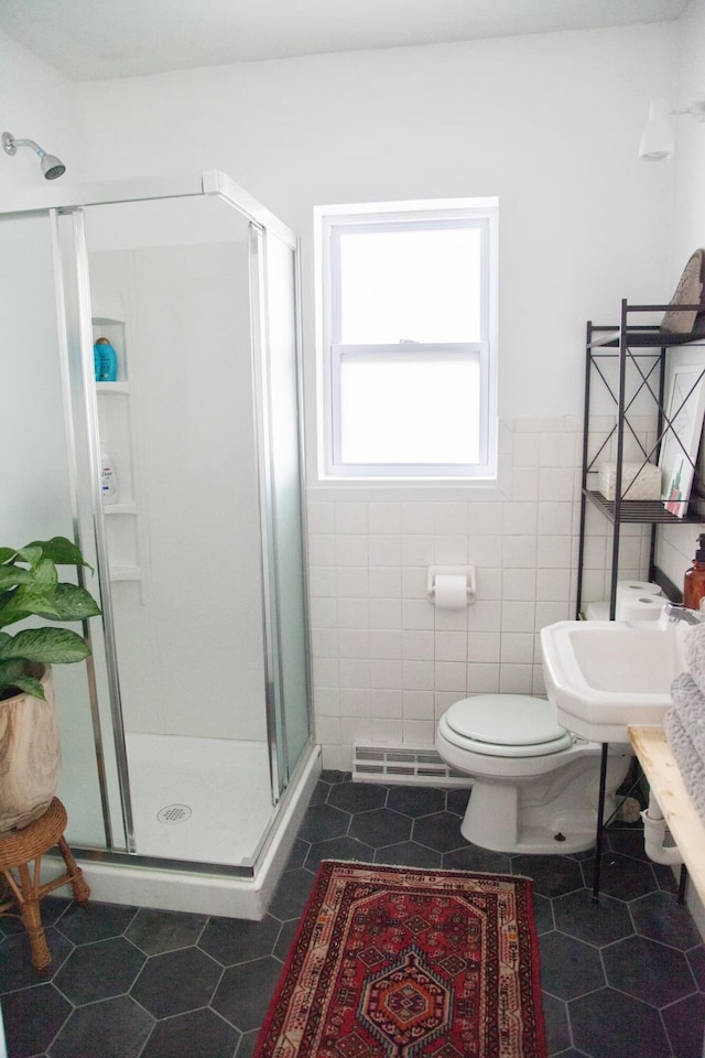 full bath featuring toilet, visible vents, tile walls, a shower stall, and tile patterned floors