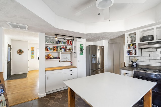 kitchen with black / electric stove, under cabinet range hood, visible vents, stainless steel refrigerator with ice dispenser, and open shelves