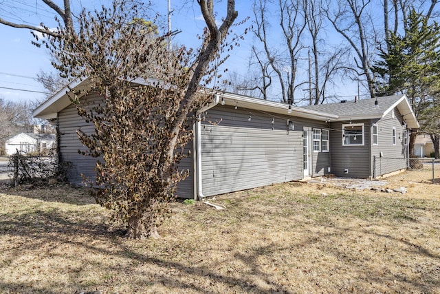 view of side of property with fence and a lawn