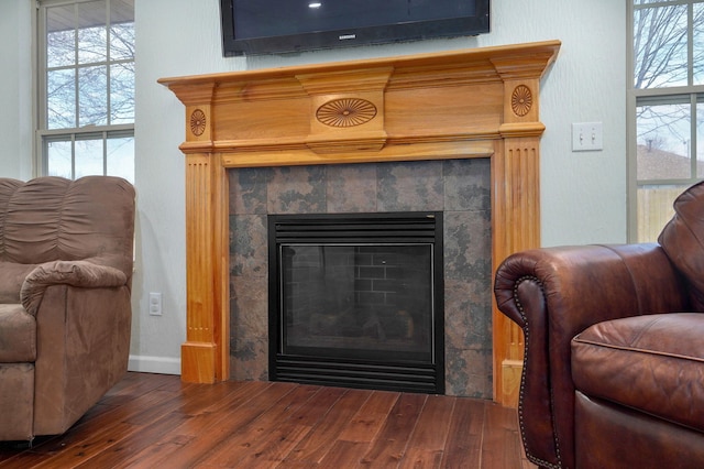 interior details featuring wood finished floors and a tile fireplace