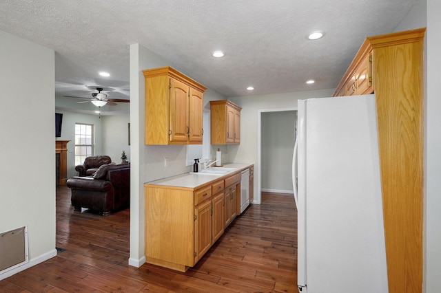 kitchen featuring white appliances, dark wood finished floors, light countertops, a sink, and recessed lighting