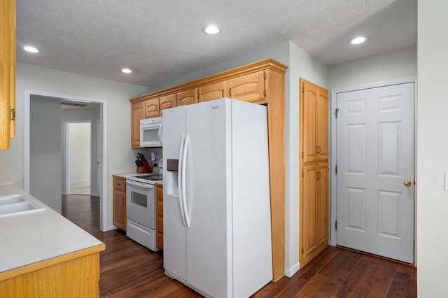 kitchen featuring a textured ceiling, recessed lighting, white appliances, light countertops, and dark wood-style floors