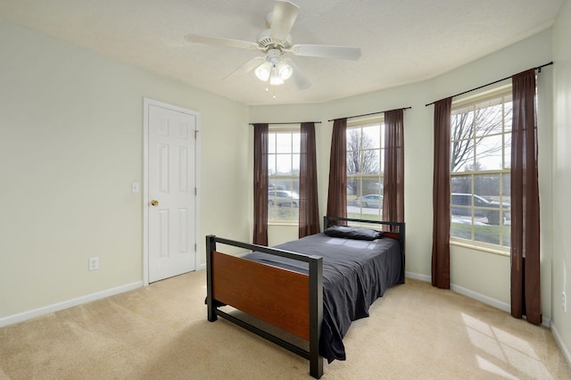 bedroom with light carpet, baseboards, and multiple windows