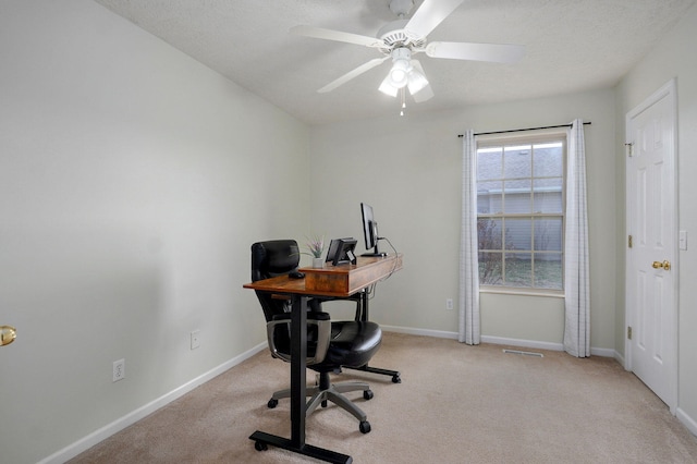 office with light carpet, a textured ceiling, a ceiling fan, and baseboards