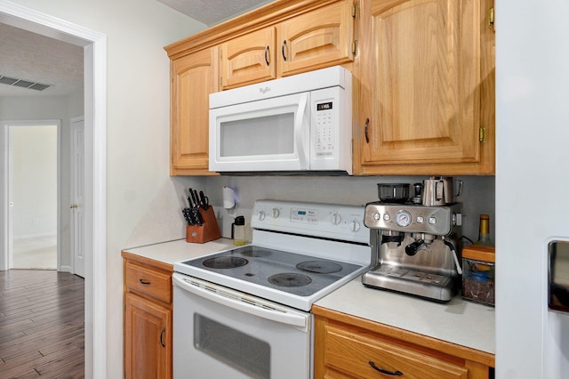 kitchen featuring white appliances, visible vents, wood finished floors, light countertops, and a textured ceiling