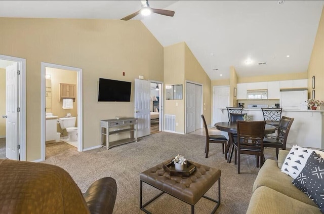 living room featuring visible vents, high vaulted ceiling, a ceiling fan, and light colored carpet