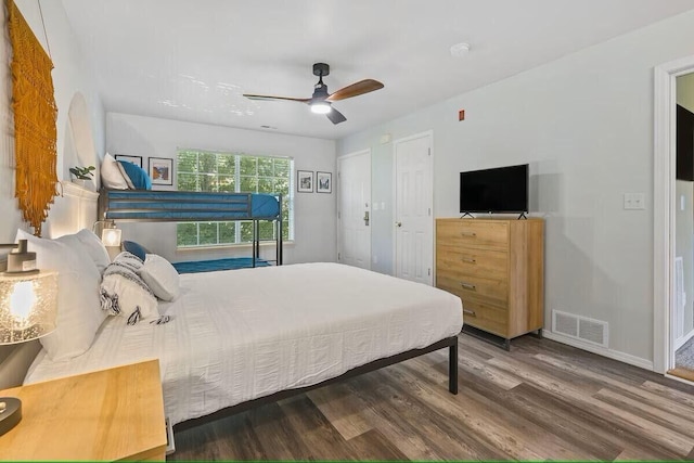 bedroom featuring baseboards, ceiling fan, visible vents, and wood finished floors