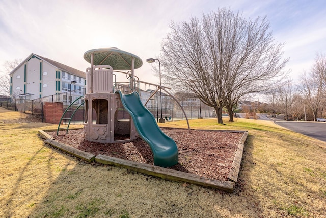 community jungle gym with fence and a yard