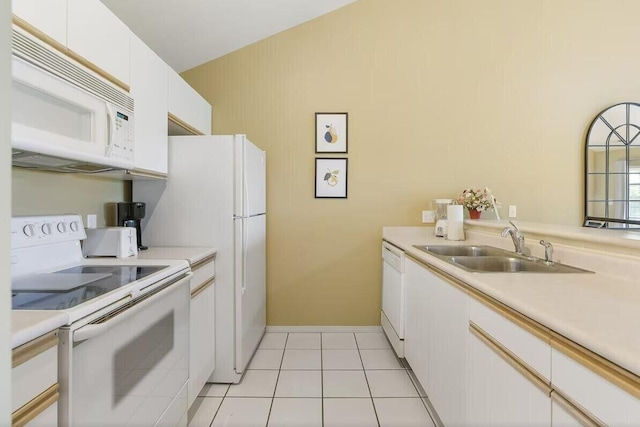 kitchen featuring white appliances, light tile patterned floors, light countertops, white cabinetry, and a sink