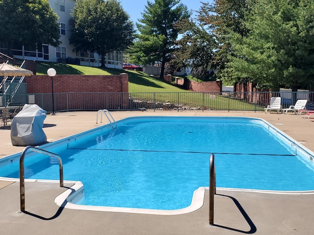 pool with fence, a lawn, and a patio