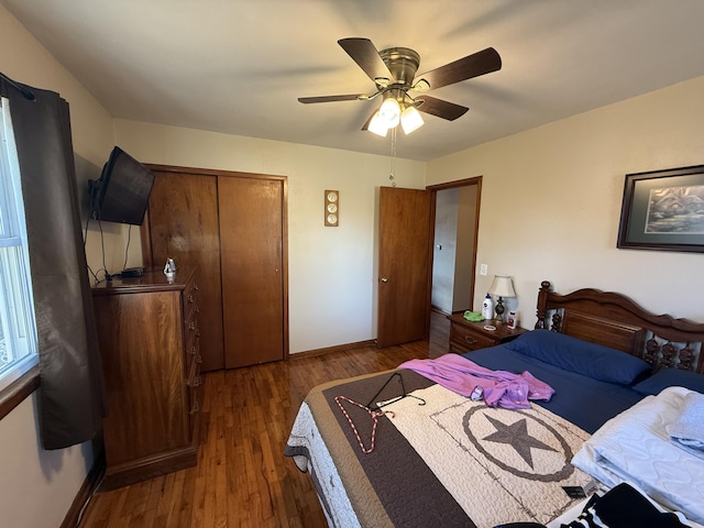 bedroom featuring a closet, ceiling fan, baseboards, and wood finished floors