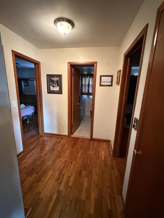 hall featuring baseboards and wood finished floors