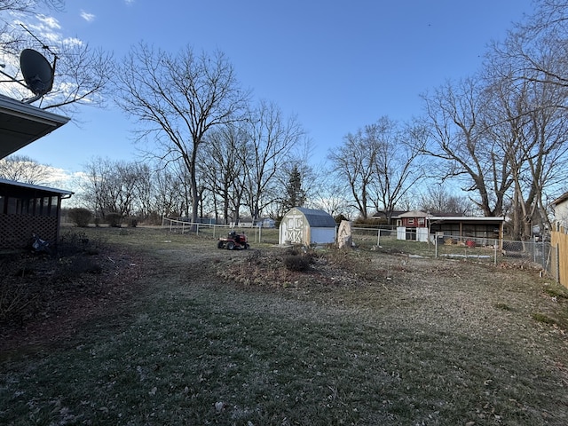 view of yard with a shed, fence, and an outbuilding