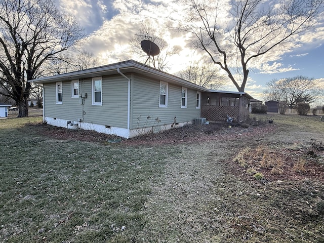 view of side of property featuring a yard, crawl space, and a sunroom