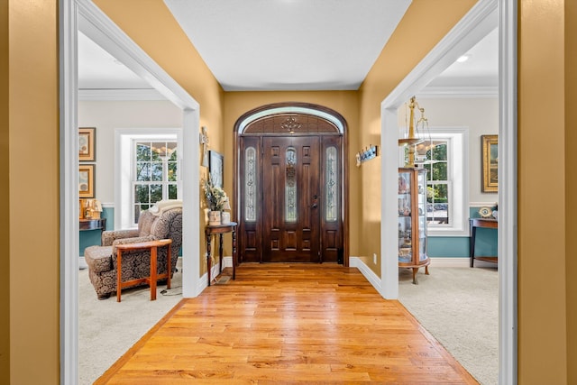 entrance foyer featuring light wood-style floors, light carpet, plenty of natural light, and baseboards