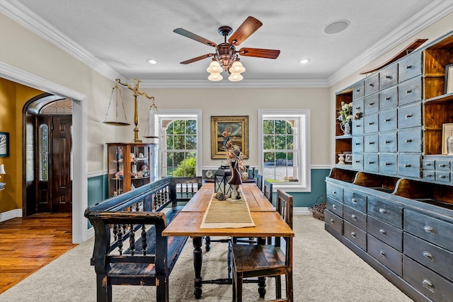 carpeted dining area with plenty of natural light, baseboards, and crown molding