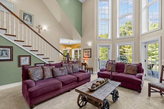 living room with baseboards, stairs, a chandelier, and carpet flooring