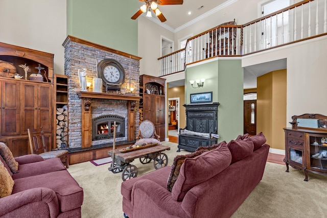 living area featuring ornamental molding, a stone fireplace, a high ceiling, and baseboards