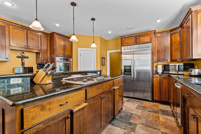 kitchen featuring brown cabinets, stainless steel appliances, and hanging light fixtures