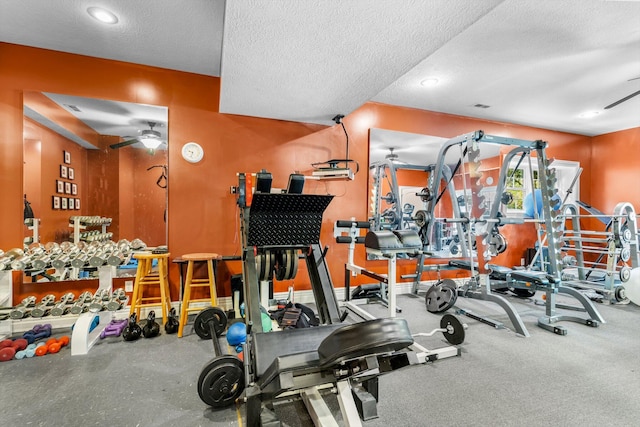 exercise room with a textured ceiling, ceiling fan, and baseboards