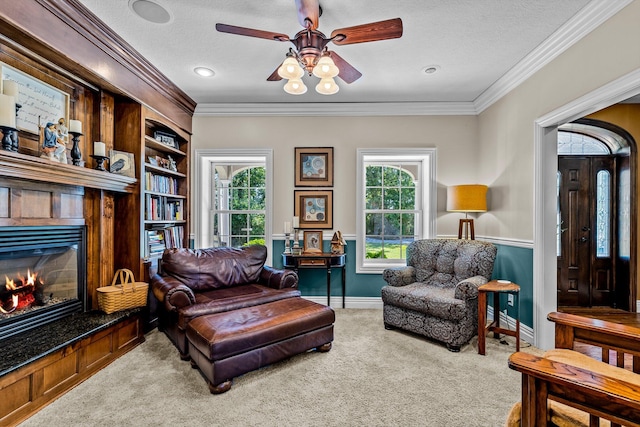 sitting room featuring a textured ceiling, carpet, a fireplace, and crown molding