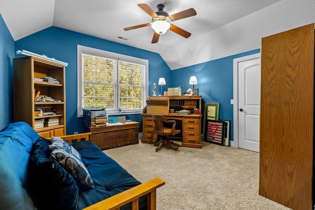 carpeted home office featuring lofted ceiling, visible vents, and a ceiling fan