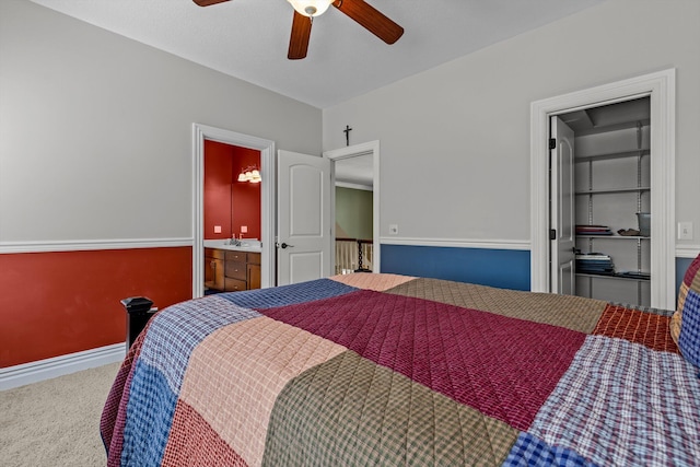 carpeted bedroom featuring a ceiling fan, baseboards, and ensuite bathroom