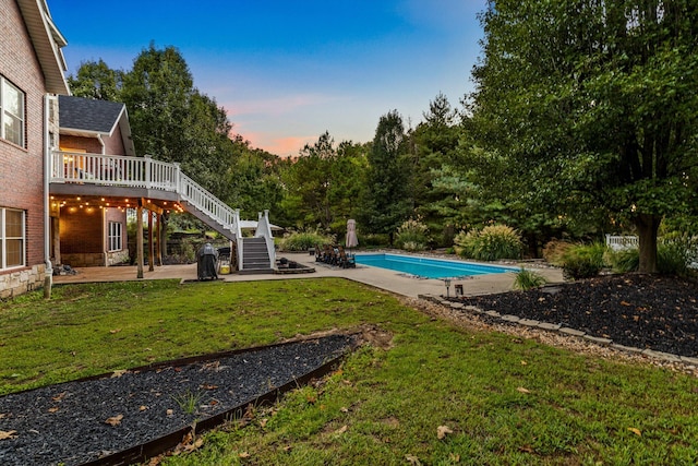 pool with a yard, stairway, a patio area, and a wooden deck