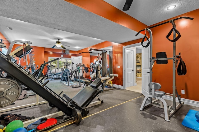 exercise room with a textured ceiling, visible vents, a ceiling fan, and baseboards