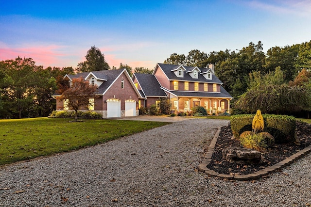 view of front of home with a garage, gravel driveway, and a yard