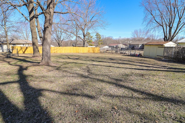 view of yard with fence, an outdoor structure, and a shed