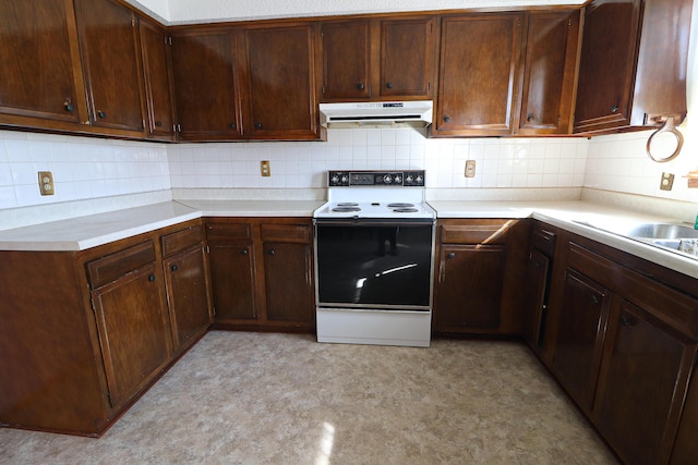 kitchen featuring range with electric cooktop, backsplash, light countertops, and under cabinet range hood