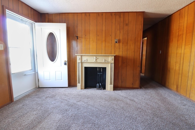 unfurnished living room with carpet floors and wood walls