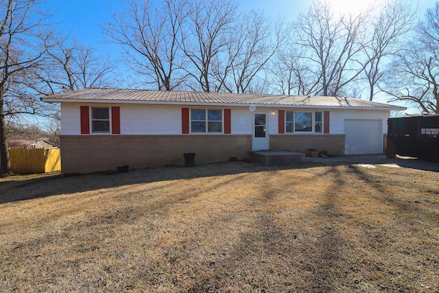 single story home featuring metal roof, an attached garage, brick siding, fence, and a front yard