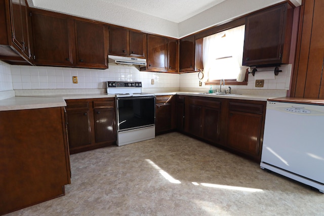 kitchen featuring white appliances, light countertops, a sink, and under cabinet range hood