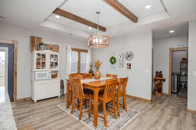 dining area featuring plenty of natural light, light wood-style flooring, baseboards, and beam ceiling