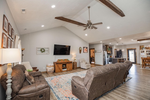 living room featuring lofted ceiling, light wood-style floors, ceiling fan, and recessed lighting