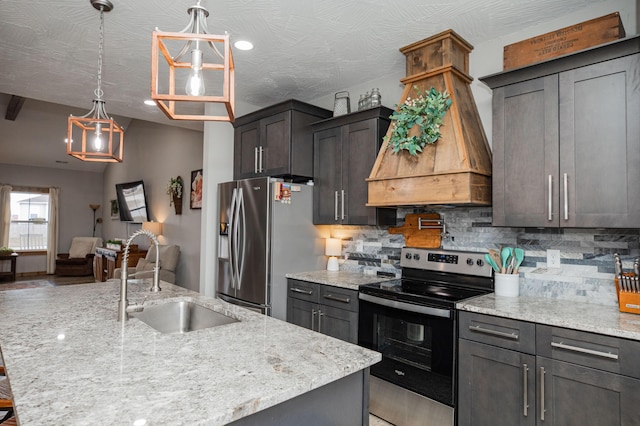 kitchen with backsplash, appliances with stainless steel finishes, a sink, an island with sink, and premium range hood