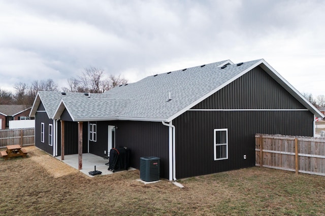 back of house featuring central air condition unit, a patio area, a shingled roof, and fence