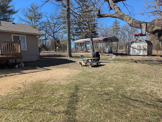 view of yard with a storage shed, a carport, and an outbuilding