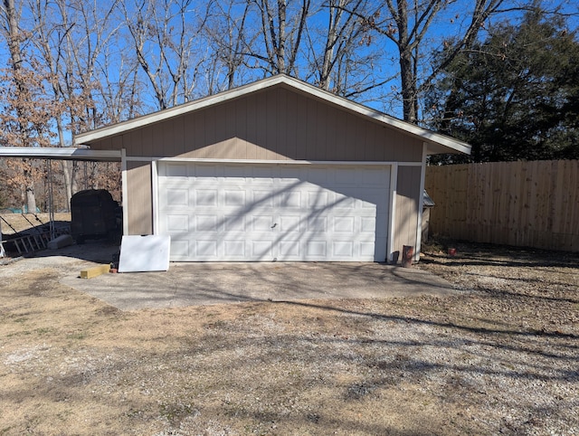 detached garage featuring fence