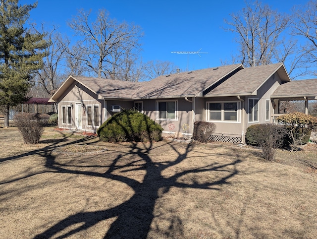 back of house featuring roof with shingles