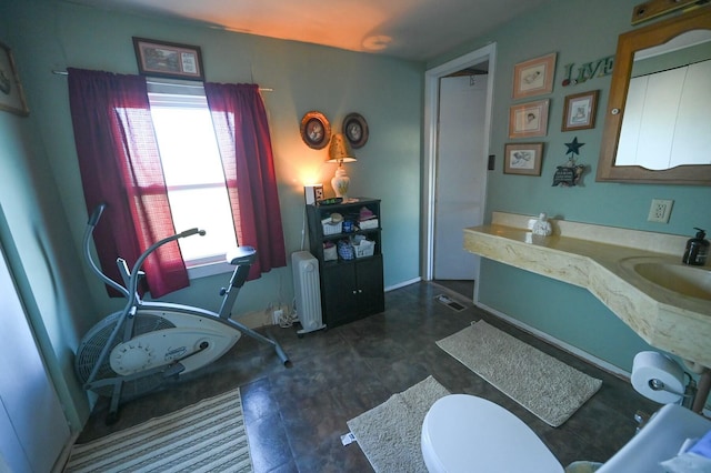 bathroom with toilet, radiator heating unit, visible vents, and a sink